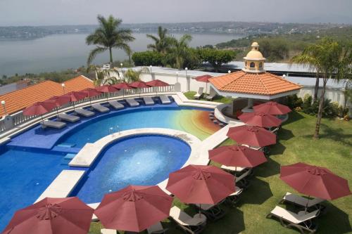 een luchtzicht op een zwembad van het resort met parasols bij Excelaris Grand Resort Conventions & Spa in Tequesquitengo