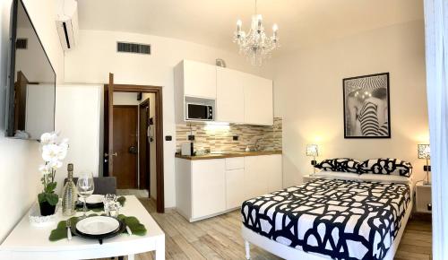 a bedroom with a black and white bed and a kitchen at Leonardo & Davide Apartment Florence in Florence