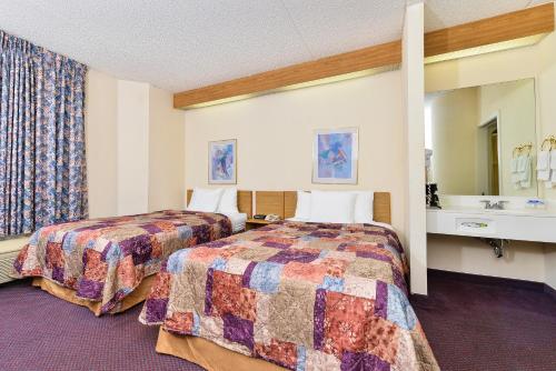 a hotel room with two beds and a sink at America's Best Value Inn & Suites, Atlanta - Morrow in Morrow