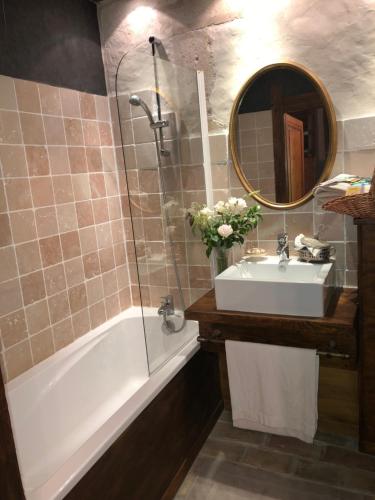 a bathroom with a sink and a tub and a mirror at Domaine du Très-Haut - Château de Montanges in Montanges