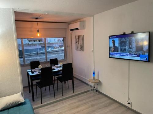 d'une salle à manger avec une table et une télévision murale. dans l'établissement Appartement neuf cap d'agde location, au Cap d'Agde