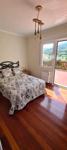 a bedroom with a bed and a large window at Casa con encanto in Cariño