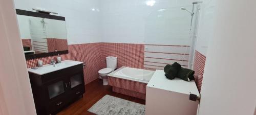 a bathroom with a tub and a sink and a toilet at Casa con encanto in Cariño