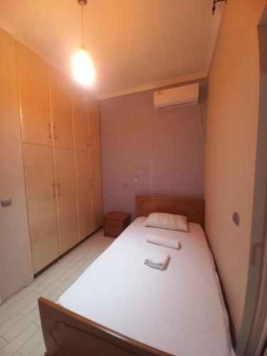 a small room with a white bed and a light at Arjana & Nelaj Apartments in Ksamil