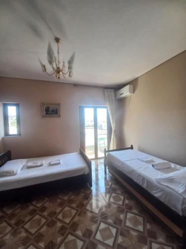 a bedroom with two beds and a chandelier at Arjana & Nelaj Apartments in Ksamil