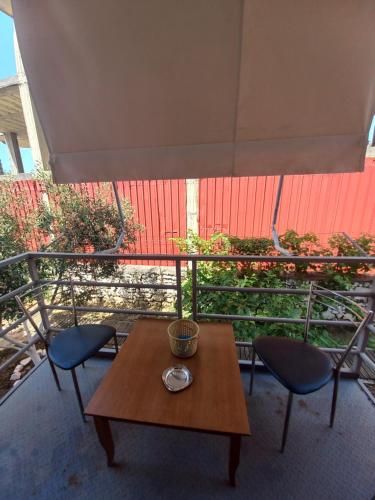 a table and two chairs and a large umbrella at Arjana & Nelaj Apartments in Ksamil