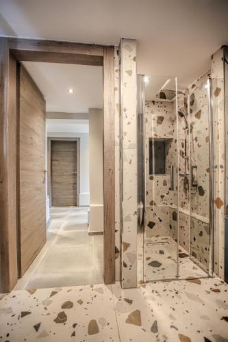 a bathroom with a shower with a glass door at Avli Luxurious House in Kalabaka