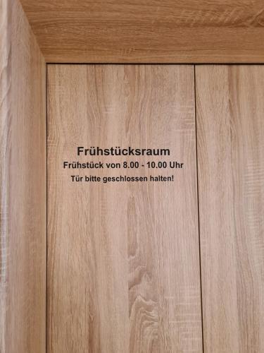 a wooden door with a sign on it at Hotel Pension Nordzeit in Norddeich