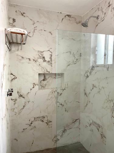 a bathroom with a shower with a glass door at AZUL ARENA Hotel Boutique in Mazatlán