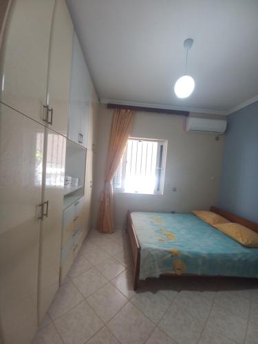 a small bedroom with a bed and a window at Arjana & Nelaj Apartments in Ksamil