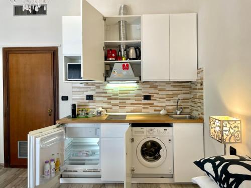 a kitchen with white cabinets and a washer and dryer at Leonardo & Davide Apartment Florence in Florence