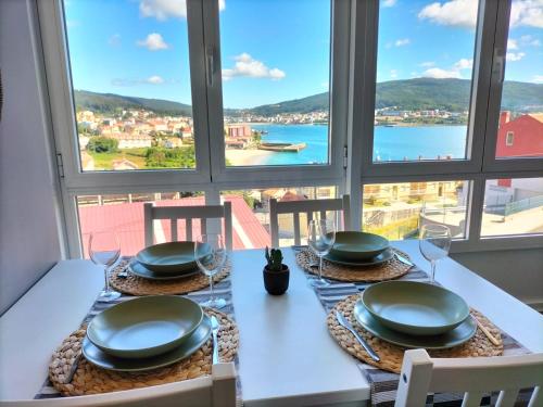 a dining table with a view of the water at O Vendaval in Corcubión