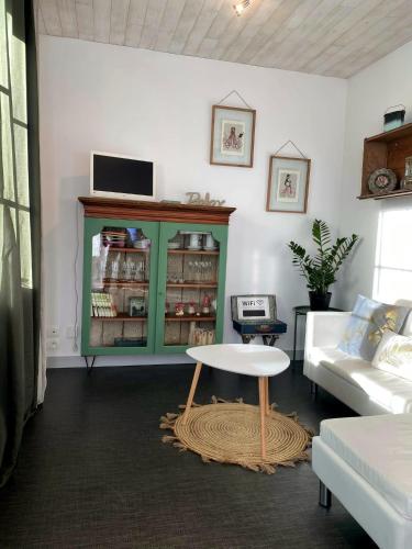 un salon avec une armoire verte et une table dans l'établissement La p'tite HAPPY, à Arvert