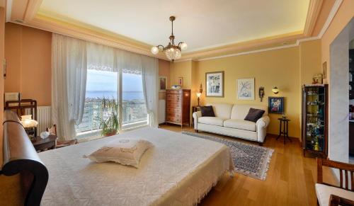 een grote slaapkamer met een groot bed en een bank bij Living exceptionally in Thessaloniki