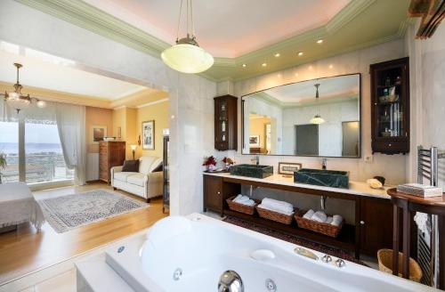 een badkamer met een bad en een grote spiegel bij Living exceptionally in Thessaloniki