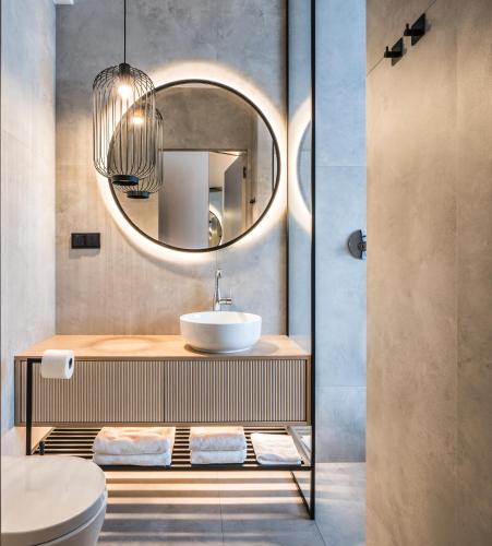a bathroom with a sink and a mirror at Masuria Apartments in Giżycko