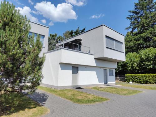 a white house with a balcony at Apartment Sloneczny Grodek 68 in Gródek Nad Dunajcem