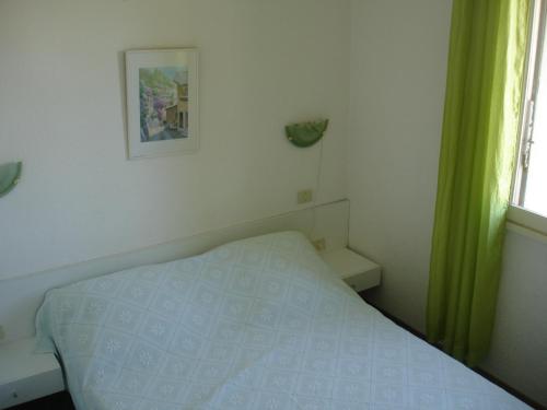 une petite chambre avec un lit et une fenêtre dans l'établissement cap d'agde 54m2 face à la mer, au Cap d'Agde