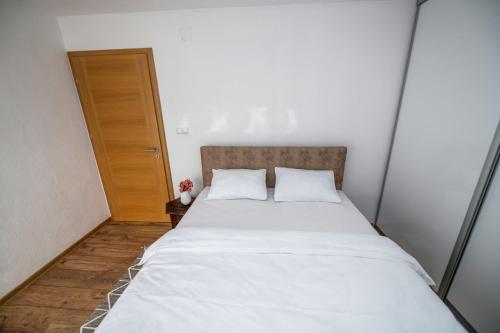 a bedroom with a large bed with white sheets at Apartmani Adi&Ena in Konjic