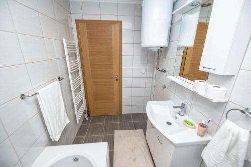 a white bathroom with a sink and a toilet at Apartmani Adi&Ena in Konjic
