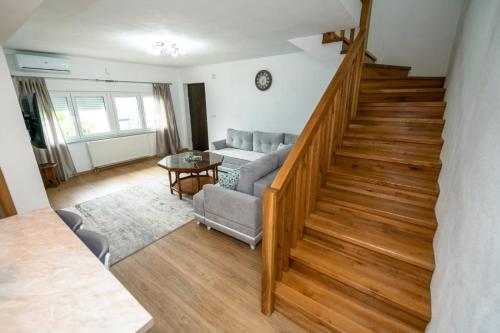 a living room with a staircase with a couch and a table at Apartmani Adi&Ena in Konjic