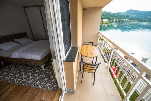 a room with a balcony with a bed and a table at Apartmani Adi&Ena in Konjic