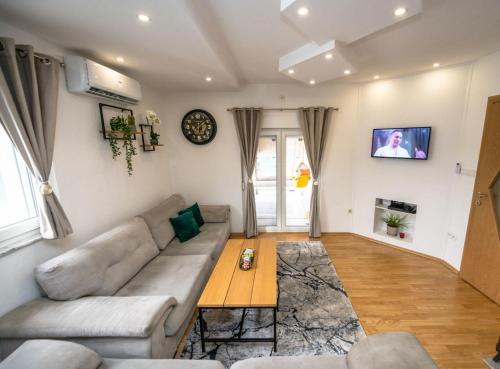 a living room with a couch and a table at Apartmani Adi&Ena in Konjic