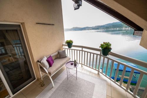 a balcony with a couch and a view of the water at Apartmani Adi&Ena in Konjic