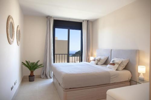 a bedroom with a bed and a large window at Luxury Spa Resort Marbella 2 bedroom sauna gym pools jacuzzi in Marbella