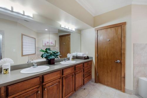 Un baño con dos lavabos y un espejo grande. en Best Western Plus Loveland Inn, en Loveland