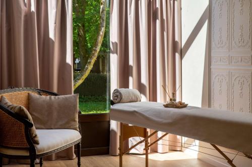 a room with a table and a chair and a window at Les Demeures de Varennes, BW Signature Collection in Varennes-Jarcy