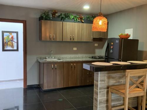 a kitchen with wooden cabinets and a black refrigerator at Cabaña en coveñas en acogedor conjunto residencial in Coveñas