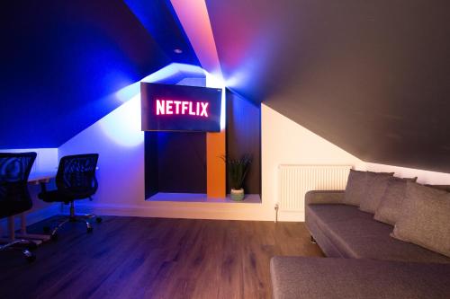 a living room with a netflix sign on the wall at Bright cheery 4 bd apartment by Brighton Station in Brighton & Hove