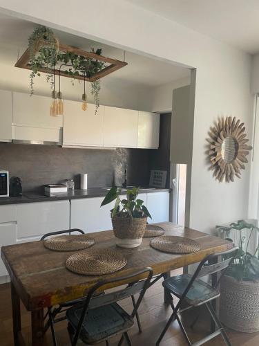- une cuisine avec une table en bois et des plantes dans l'établissement Le Magilena T2, à Cannes