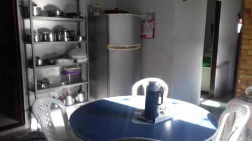 una mesa azul y sillas en una cocina con nevera en Uma casa para descansar em um cenário paradisíaco., en Icapuí
