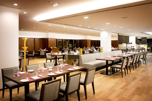 a restaurant with tables and chairs and a bar at Seoul Garden Hotel in Seoul