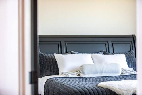 a bed with a black headboard and white pillows at Luxury Living at The Eagles Perch Palmer AK in Palmer