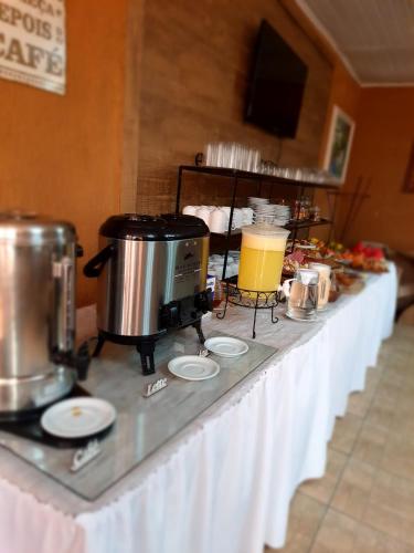 a table with a coffee maker on top of it at La Campaña in São Gabriel