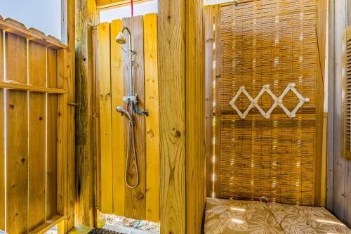 uma casa de banho com um chuveiro numa parede de madeira em The Bay House em Dauphin Island