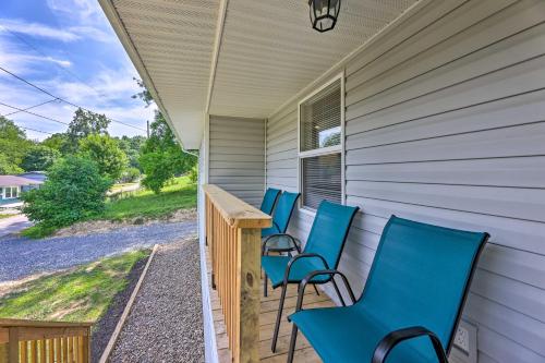 a row of blue chairs on the porch of a house at Pet-Friendly Digs with Fire Pit and Large Yard! in Fayetteville