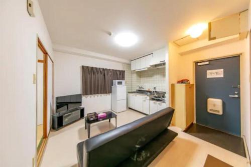 a kitchen with a couch in the middle of a room at Ash Court Joto in Osaka