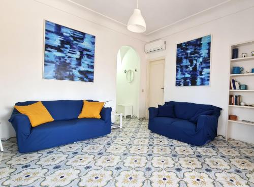 a living room with two blue couches at Villa Matisse - Damecuta Park in Anacapri