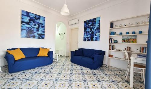 a living room with two blue couches and a table at Villa Matisse - Damecuta Park in Anacapri