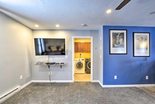 a living room with blue walls and a washer and dryer at Cozy Getaway - 10 Miles to Mount Wachusett Skiing! in Leominster