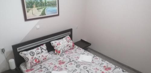 Un dormitorio con una cama con sábanas y almohadas rosas y blancas. en Exit Labirint Centar en Novi Sad
