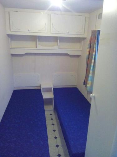 a small room with a blue floor and white cabinets at EAGLE BIWAK in Pozezdrze