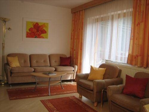 a living room with a couch and chairs and a window at Ferienwohnungen Pötscher Maria in Matrei in Osttirol