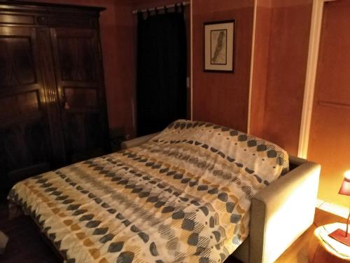 Una cama en un dormitorio con una manta. en Solution de dépannage - chez l'habitant, en Le Creusot