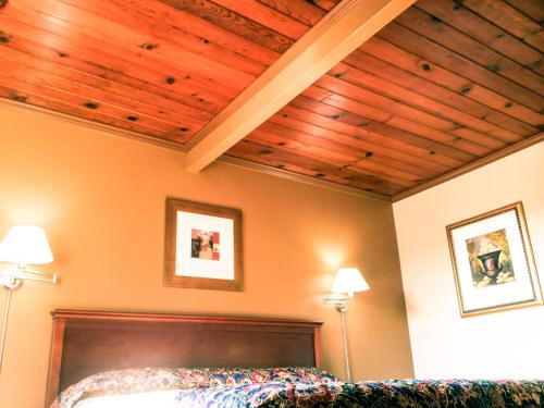 een slaapkamer met een bed en houten plafonds bij Marina Inn in Berkeley