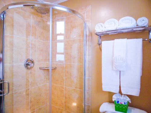uma casa de banho com um chuveiro, toalhas e um WC. em Marina Inn em Berkeley